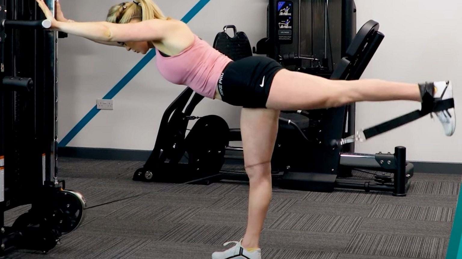 PT demonstrating how to do cable kickbacks