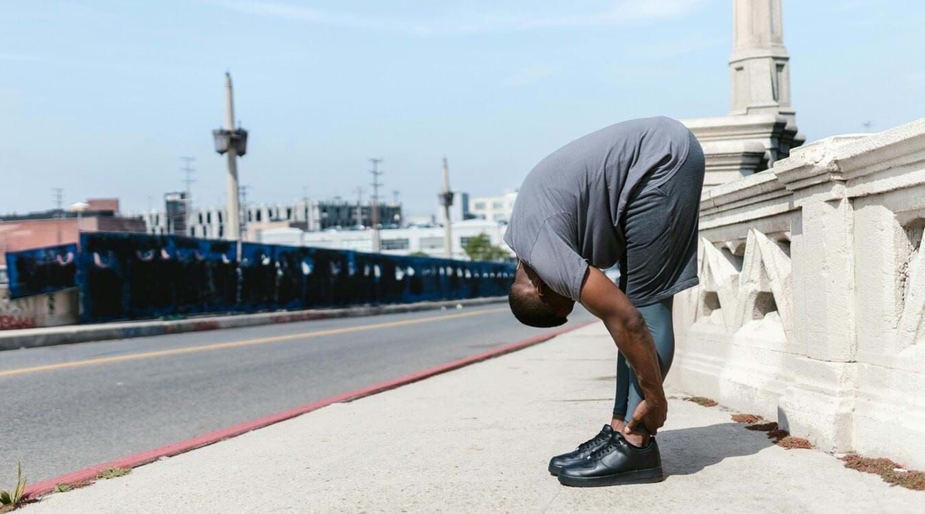 Man stretching on bridge
